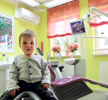 Kind freundlich auf Behandlerstuhl sitzend wartet auf Patient