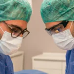 Dr. Neubert und Dr. Weich bei einer chirurgischen Tätigkeit in OP-Bekleidung